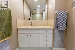 Vanity featuring a built-in sink, light-toned countertop, and white cabinetry with storage drawers - 