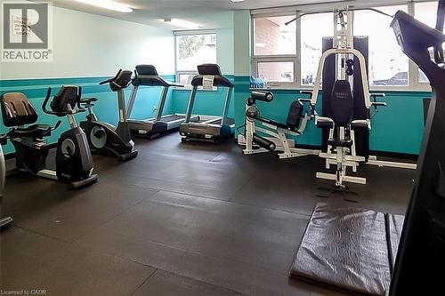 Fitness center featuring a comprehensive selection of exercise equipment, durable rubber flooring, and ample natural light from multiple windows - 500 Green Road Unit# 901, Stoney Creek, ON - Indoor Photo Showing Gym Room
