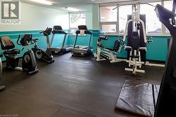 Fitness center featuring a comprehensive selection of exercise equipment, durable rubber flooring, and ample natural light from multiple windows - 