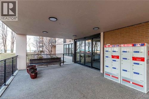 Building entrance featuring automatic glass doors, a brick facade, and an exterior covered walkway - 500 Green Road Unit# 901, Stoney Creek, ON - 