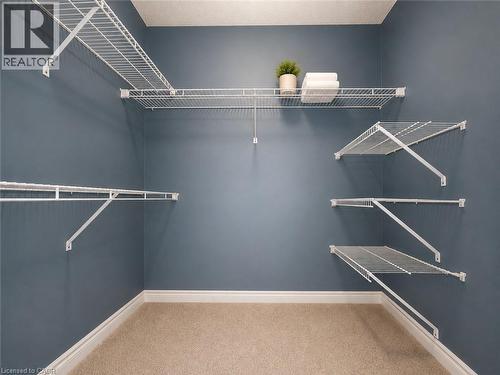 Walk-in closet with multi-level wire shelving, white baseboards, and neutral-toned carpeting - 255 Keats Way Unit# 606, Waterloo, ON - Indoor With Storage