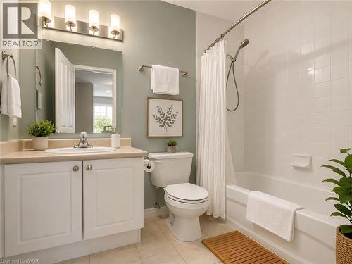Bathroom featuring a white vanity with a light-colored countertop and integrated sink, a large mirror, and a four-light fixture - 255 Keats Way Unit# 606, Waterloo, ON - Indoor Photo Showing Bathroom