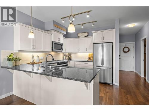 White Kitchen with Granite Countertops - 3735 Casorso Road Unit# 410, Kelowna, BC - Indoor Photo Showing Kitchen With Stainless Steel Kitchen With Double Sink With Upgraded Kitchen