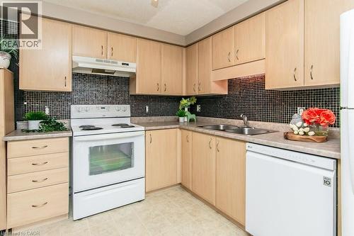 Kitchen featuring light wood-finish cabinetry, black mosaic tile backsplash, and light-toned countertops - 71 Foxglove Crescent, Kitchener, ON - Indoor Photo Showing Kitchen With Double Sink