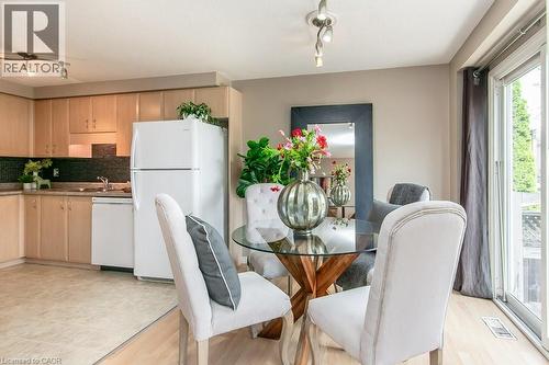 Kitchen and dining area featuring light wood cabinetry, dark tile backsplash, and a sliding glass patio door - 71 Foxglove Crescent, Kitchener, ON - Indoor Photo Showing Dining Room