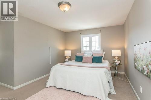 Carpeted room featuring a double-paned window, a flush-mount ceiling light fixture, and neutral-toned walls - 71 Foxglove Crescent, Kitchener, ON - Indoor Photo Showing Bedroom