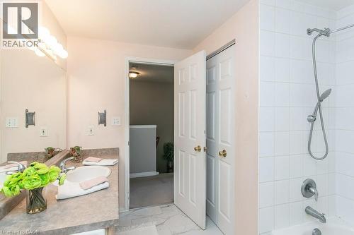 Bathroom featuring a vanity with an integrated sink, a large wall mirror, and a multi-bulb light fixture - 71 Foxglove Crescent, Kitchener, ON - Indoor Photo Showing Bathroom