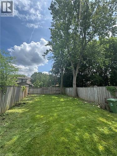 Expansive backyard featuring a manicured lawn, established perimeter fencing, and mature trees providing natural shade - 21 Haddon Avenue S, Hamilton, ON 