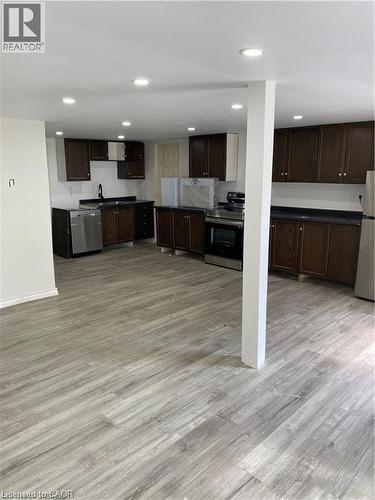 Spacious kitchen area featuring wood-finish flooring, recessed lighting, dark wood cabinetry, stainless steel appliances, and dark countertops - 28 Derner Line, Lowbanks, ON - Indoor Photo Showing Kitchen