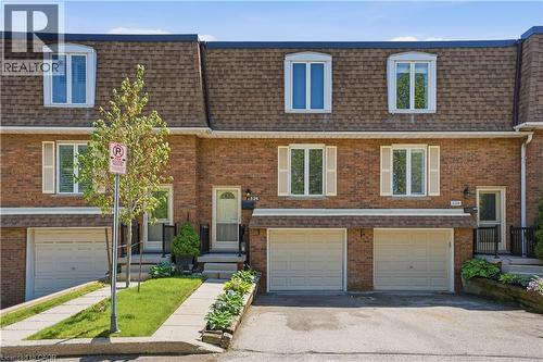 Brick facade townhome with a gambrel roof and dormer windows - 1526 Westminster Place, Burlington, ON - Outdoor With Facade