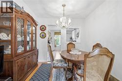 Dining area featuring wood-finish flooring and a crystal chandelier - 