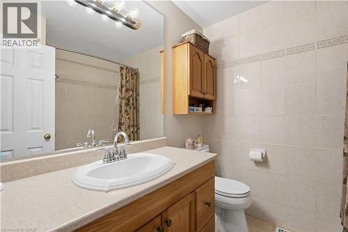 Bathroom with a light-colored vanity featuring an oval sink and chrome faucet - 1526 Westminster Place, Burlington, ON - Indoor Photo Showing Bathroom