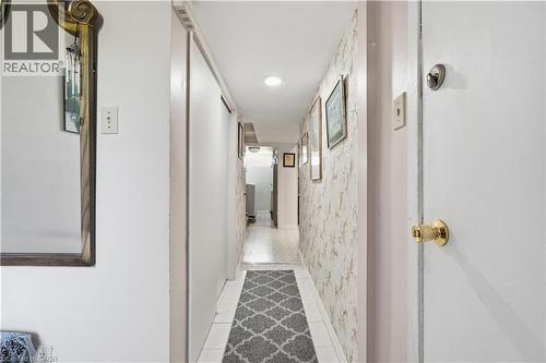 Hallway featuring white tile flooring, recessed lighting, and a textured wall finish - 1526 Westminster Place, Burlington, ON - Indoor