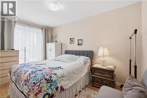 Bedroom featuring wood-finish flooring, light-toned walls, a semi-flush mount ceiling light, and a double window with blinds and drapes - 1526 Westminster Place, Burlington, ON - Indoor Photo Showing Bedroom