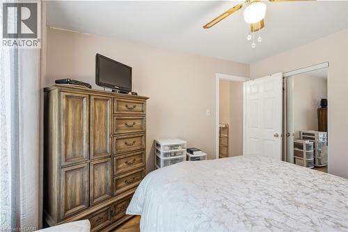 Bedroom featuring a ceiling fan with integrated lighting, wood-finish flooring, and a closet with bifold doors - 1526 Westminster Place, Burlington, ON - Indoor Photo Showing Bedroom