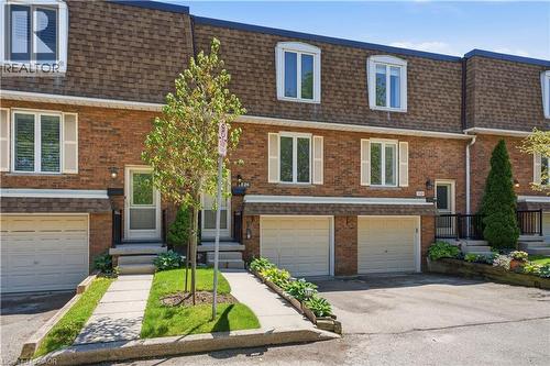 Brick townhouse exterior with a mansard roof - 1526 Westminster Place, Burlington, ON - Outdoor With Facade