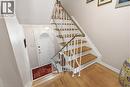 Entryway featuring wood-finish flooring, a white paneled door with an arched glass insert, a white wrought iron staircase railing with a brass-finish handrail, and white baseboards - 1526 Westminster Place, Burlington, ON  - Indoor Photo Showing Other Room 