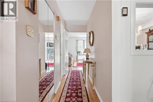 Hallway featuring wood-finish flooring, light-toned wall paint, and a mirrored wall panel - 1526 Westminster Place, Burlington, ON - Indoor Photo Showing Other Room