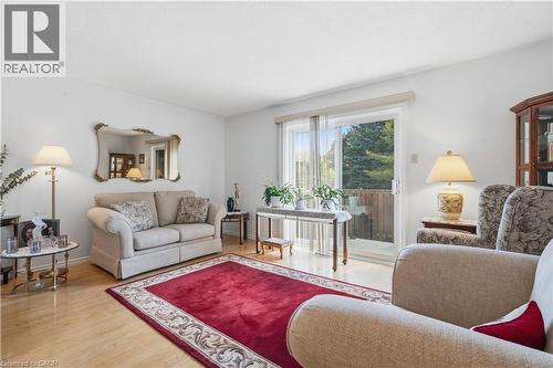 Bright living area featuring wood-finish flooring, white walls, and a glass sliding door - 1526 Westminster Place, Burlington, ON - Indoor Photo Showing Living Room