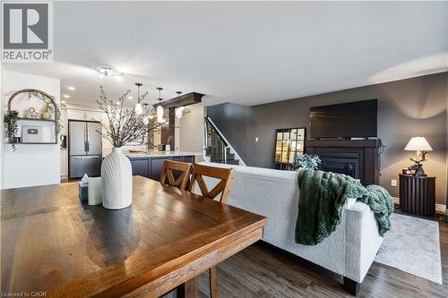 Open-concept living space featuring wood-finish flooring, a built-in fireplace with a dark wood mantel, and recessed lighting - 27 Red Clover Crescent, Kitchener, ON - Indoor Photo Showing Dining Room