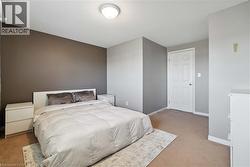 Spacious room featuring a neutral color palette, ceiling-mounted light fixture, and a paneled white door - 