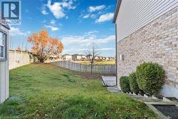 Expansive backyard featuring a manicured lawn, a privacy fence, and a mature tree - 
