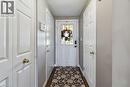 Entryway featuring a white paneled door with glass insert, wood-finish flooring, and multiple white paneled closet doors with brass hardware - 27 Red Clover Crescent, Kitchener, ON  - Indoor Photo Showing Other Room 