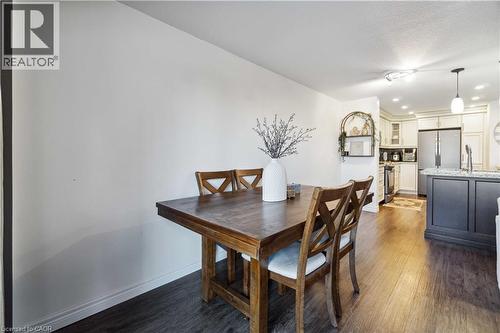 Open-concept living space featuring wood-finish flooring, recessed lighting, and a kitchen island with a stone countertop - 27 Red Clover Crescent, Kitchener, ON - Indoor Photo Showing Dining Room