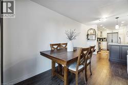 Open-concept living space featuring wood-finish flooring, recessed lighting, and a kitchen island with a stone countertop - 