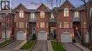 Brick-faced townhome featuring a single-car garage, arched entryways, and multiple windows across two levels - 245 Bishop Street S Unit# 31, Cambridge, ON  - Outdoor With Facade 