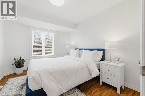 Bedroom featuring wood-finish flooring and a large window with horizontal blinds - 245 Bishop Street S Unit# 31, Cambridge, ON - Indoor Photo Showing Bedroom