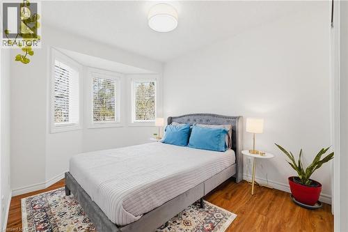 Bright bedroom featuring a three-window bay, wood-finish flooring, and white baseboards - 245 Bishop Street S Unit# 31, Cambridge, ON - Indoor Photo Showing Bedroom