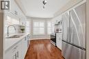 Modern kitchen featuring white cabinetry, stainless steel appliances, a subway tile backsplash, a double basin sink with a gooseneck faucet, and wood-finish flooring - 245 Bishop Street S Unit# 31, Cambridge, ON  - Indoor Photo Showing Kitchen With Double Sink With Upgraded Kitchen 