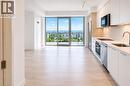 Open-concept living & dining space featuring wood-finish flooring, a contemporary kitchen with stainless steel appliances, white cabinetry, and a subway tile backsplash - 75 James Street S Unit# 2614, Hamilton, ON  - Indoor Photo Showing Kitchen With Upgraded Kitchen 