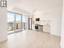 Open-concept living area with wood-finish flooring, a contemporary kitchen featuring stainless steel appliances and white cabinetry, and a private balcony with glass railing - 75 James Street S Unit# 2614, Hamilton, ON  - Indoor Photo Showing Kitchen 