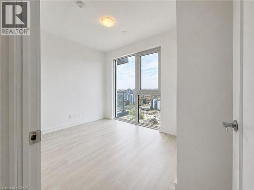 Bright room featuring a large window, light wood-finish flooring, white walls, and a ceiling-mounted light fixture - 75 James Street S Unit# 2614, Hamilton, ON - Indoor Photo Showing Other Room