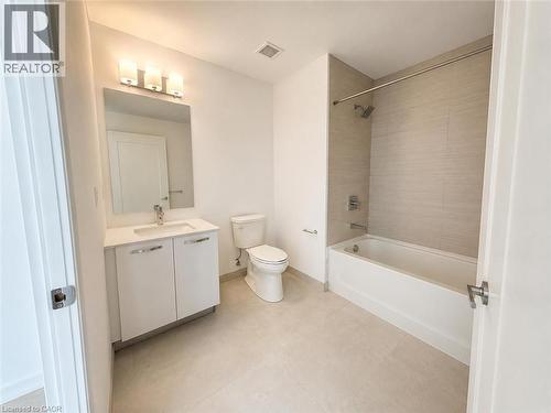 Contemporary bathroom featuring a white vanity with integrated sink, rectangular mirror, and modern three-bulb vanity lighting - 75 James Street S Unit# 2614, Hamilton, ON - Indoor Photo Showing Bathroom