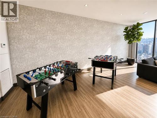 Spacious room featuring wood-finish flooring and a textured accent wall - 75 James Street S Unit# 2614, Hamilton, ON - Indoor