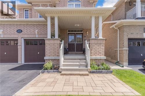 Brick facade with a covered porch featuring white columns and railing - 675 Best Road, Milton, ON - Outdoor