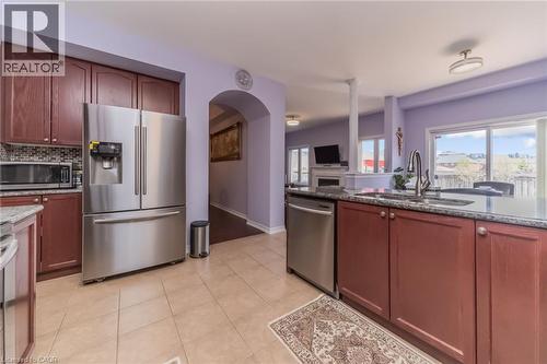 Kitchen featuring wood-finish cabinetry, stainless steel appliances, and tile flooring - 675 Best Road, Milton, ON - Indoor Photo Showing Kitchen