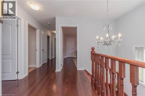 Hallway featuring wood-finish flooring, white doors, and light gray wall paint - 675 Best Road, Milton, ON - Indoor Photo Showing Other Room