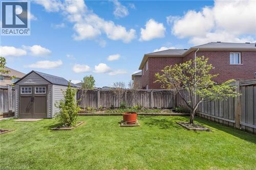 Spacious backyard featuring a manicured lawn, full privacy fencing, and a dedicated storage shed - 675 Best Road, Milton, ON - Outdoor