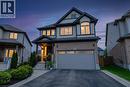 Two-story residence featuring a brick and siding exterior, an attached two-car garage, and a covered front porch with stone pillars - 916 Steepleridge Court, Kitchener, ON  - Outdoor With Facade 