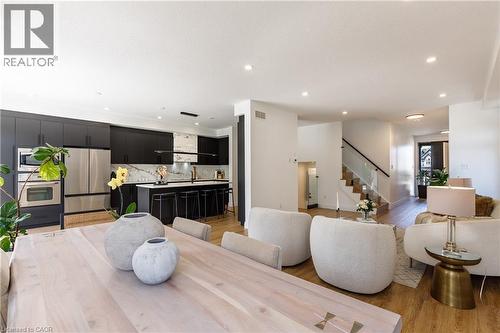 Open-concept living area featuring wood-finish flooring, recessed lighting, and a modern kitchen - 916 Steepleridge Court, Kitchener, ON - Indoor Photo Showing Living Room
