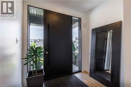 Contemporary entryway featuring a dark wood-finish door with sidelight windows, light wood-finish flooring, and crisp white walls - 916 Steepleridge Court, Kitchener, ON - Indoor Photo Showing Other Room