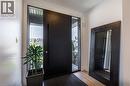 Contemporary entryway featuring a dark wood-finish door with sidelight windows, light wood-finish flooring, and crisp white walls - 916 Steepleridge Court, Kitchener, ON  - Indoor Photo Showing Other Room 