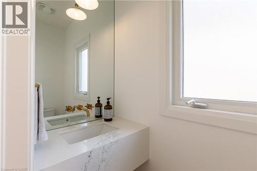 Floating vanity with an integrated sink and veined stone-finish countertop - 916 Steepleridge Court, Kitchener, ON - Indoor Photo Showing Bathroom