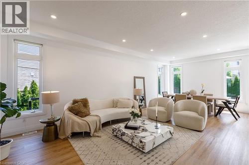 Open-concept living area with light wood-finish flooring, recessed lighting, and expansive windows - 916 Steepleridge Court, Kitchener, ON - Indoor Photo Showing Living Room