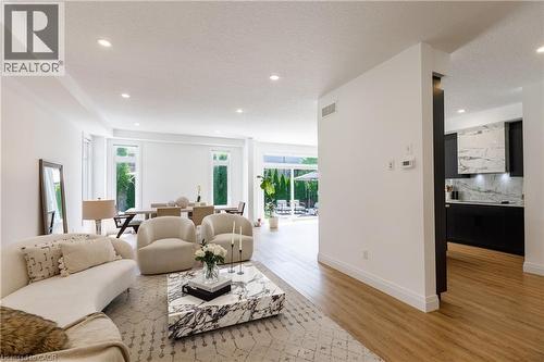 Open-concept main living area with wood-finish flooring, recessed lighting, and expansive windows - 916 Steepleridge Court, Kitchener, ON - Indoor Photo Showing Living Room