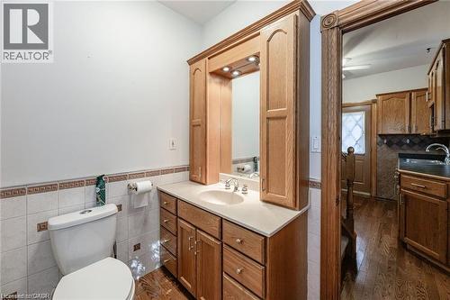 Bathroom featuring a wood vanity with a built-in mirror, overhead lighting, and a white countertop with an undermount sink - 252 Beechwood Avenue, Hamilton, ON - Indoor Photo Showing Bathroom